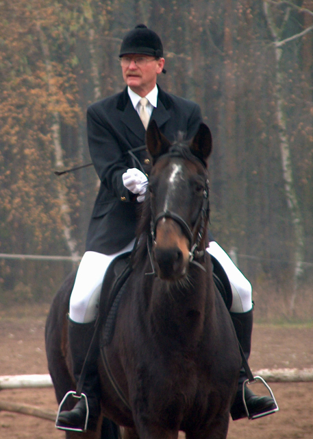 trener podczas jazdy konnej w tradycyjnym stroju jeździeckim. kurs jazdy konnej efib w poznaniu pzj.