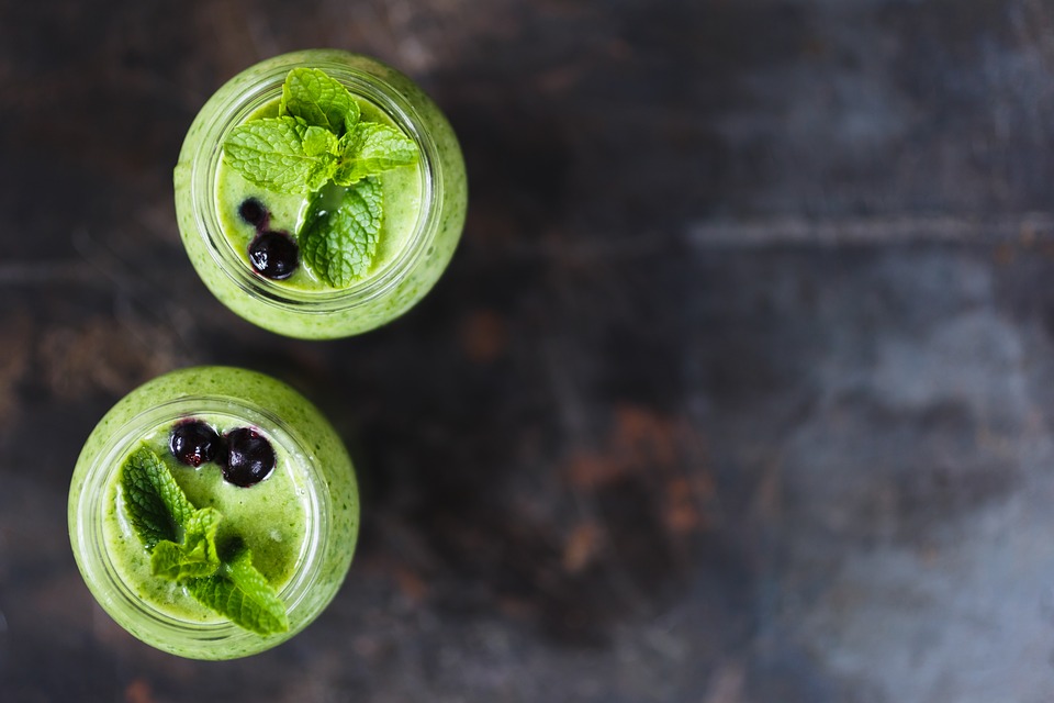 dwie szklanki z koktajlem z chlorelli i spiruliny ozdobione miętą i borówkami superfood zdrowie sprawność dietetyka zdrowe fit odżywianie