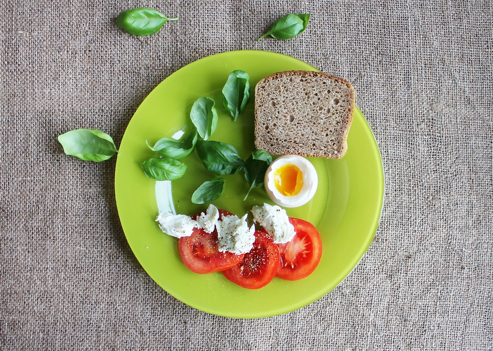 talerz z fit śniadaniem pomidor jajko twaróg zioła pełnoziarnisty chleb. zdrowe żywienie odżywianie dieta dietetyka niskie ig
