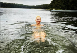 Trenerka efib pływa w jeziorze. Zdrowie relaks aktywność na świeżym powietrzu zapobieganie depresji