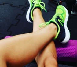 Nogi w sportowym obuwiu opierają się o roller. rollowanie mobility stretching mobilność powięź cool down