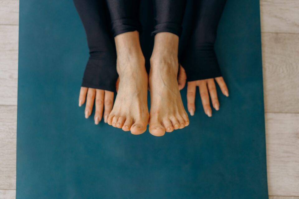 sylwetka zawodniczki ćwiczącej jogę na macie. stretching rehabilitacja stóp